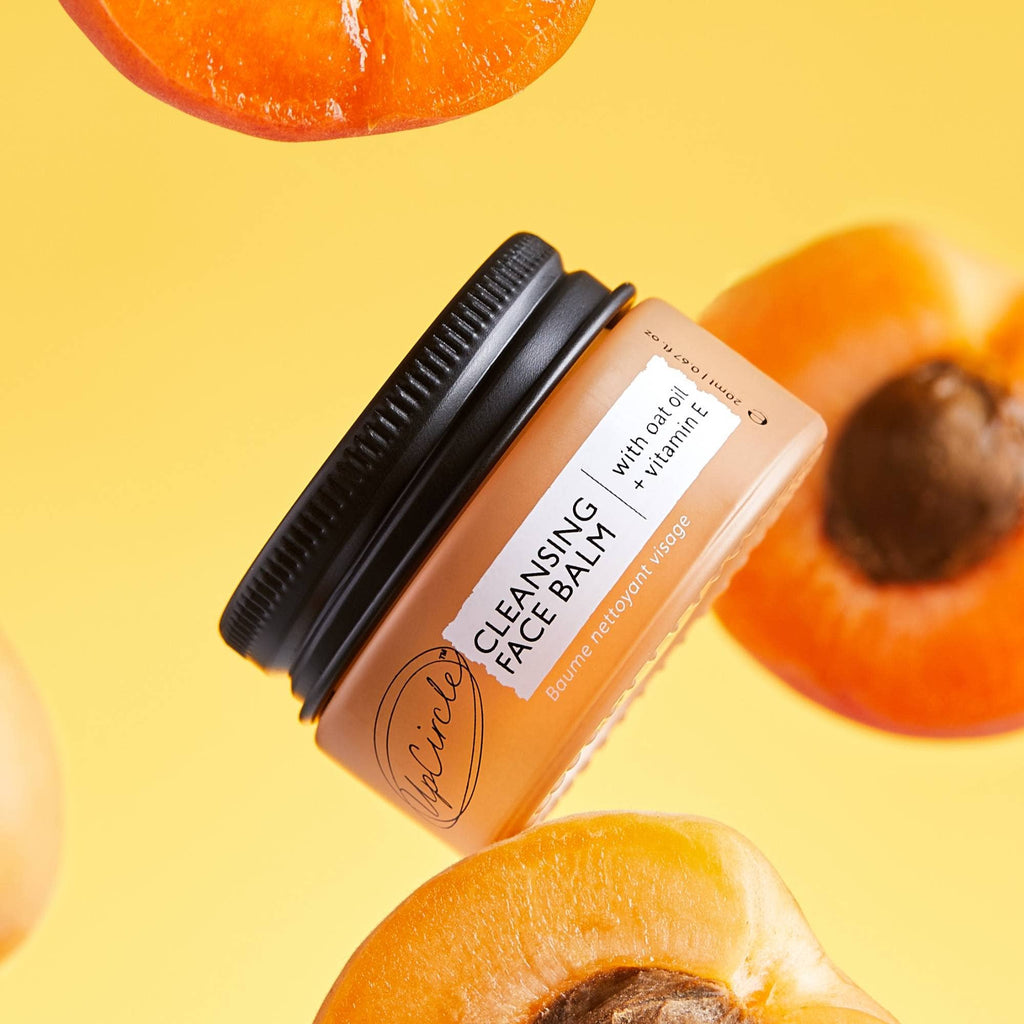 Cleansing face balm jar with apricot slices on a yellow background