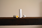 Vely Lip Balms on a wooden surface with a neutral background