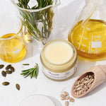 Nourish London Beauty Balm jar with natural ingredients and oils on a white background
