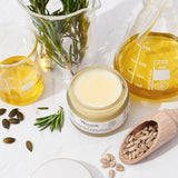 Nourish London Beauty Balm jar with natural ingredients and oils on a white background