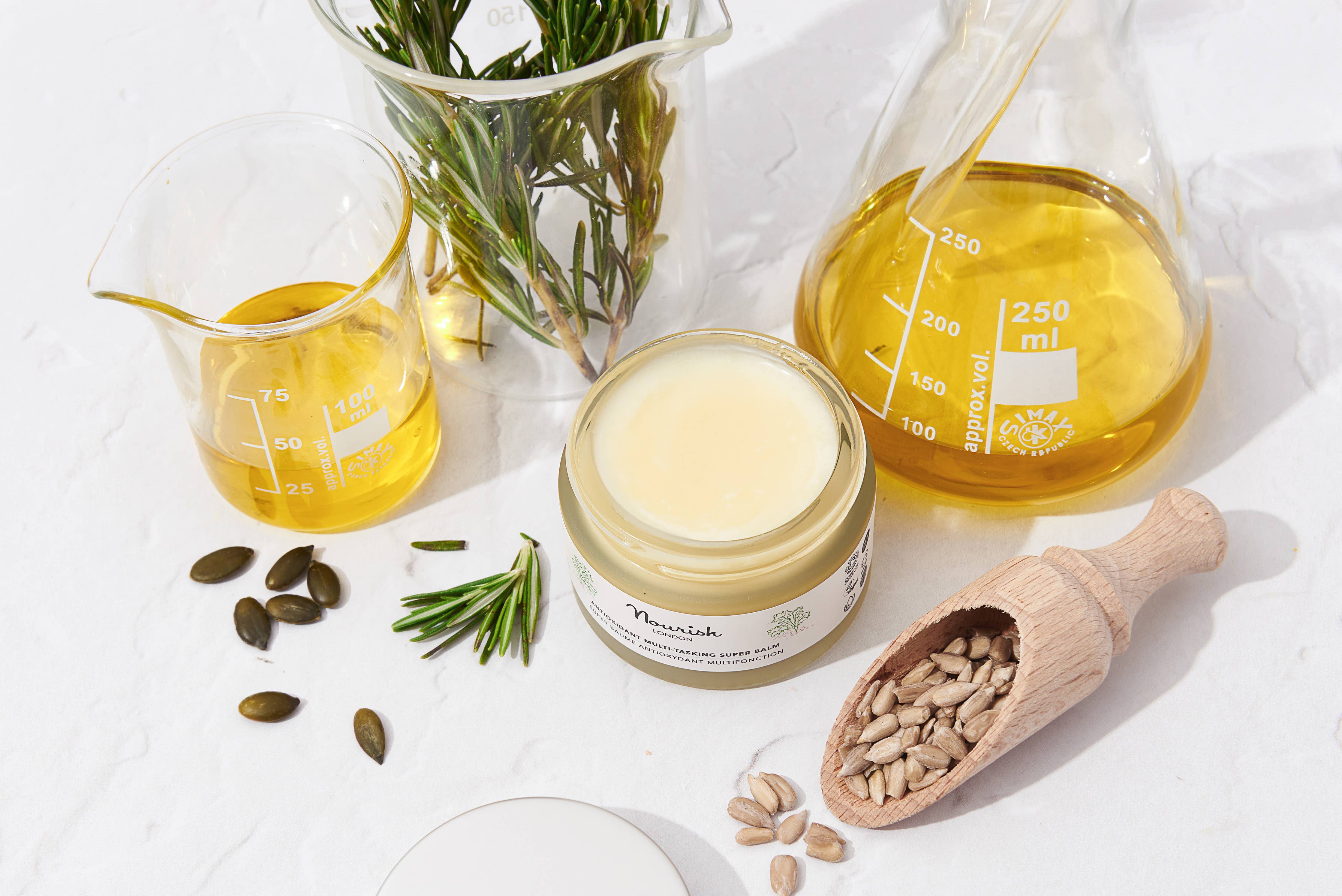 Nourish London Beauty Balm jar with natural ingredients and oils on a white background