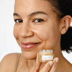 Woman holding a jar of UpCircle lip balm with a plain background