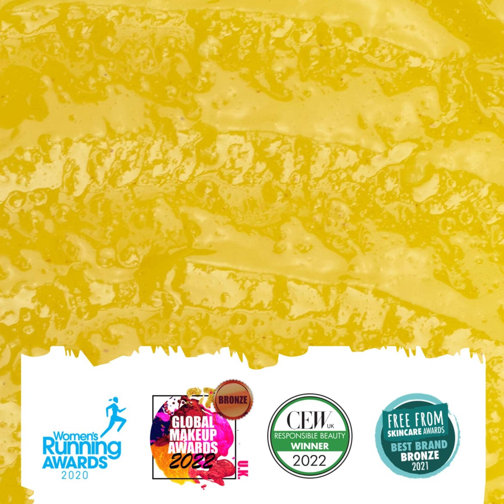 award logos on top of a colour swatch of yellow makeup remover balm