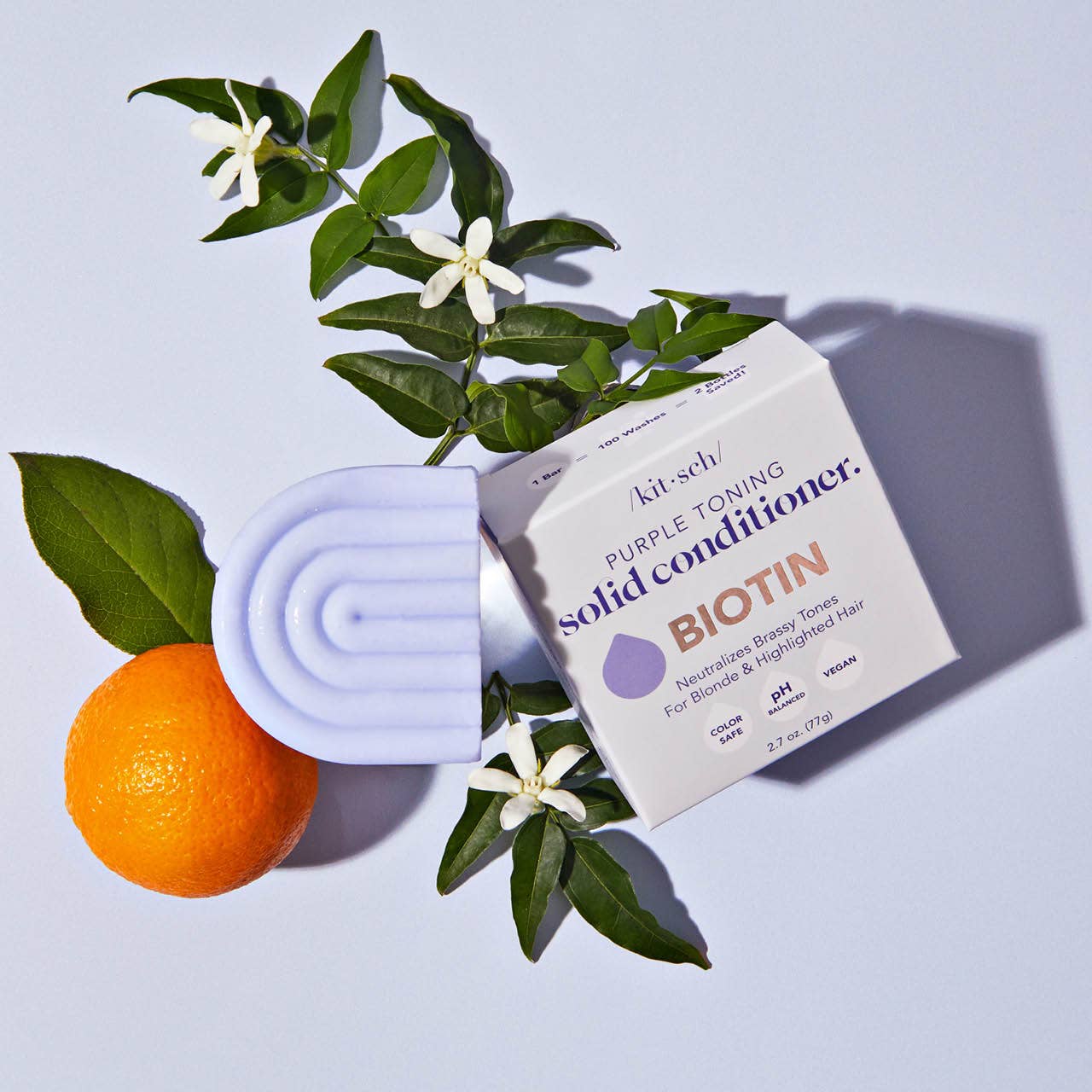 Packaging for Kitsch solid conditioner with a purple-toning bar and an orange on a light blue background