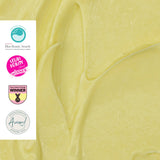 Close-up of yellow cream with Blue Beauty Awards, L'Occitane Healthy Winner, and Sustainability Award logos.