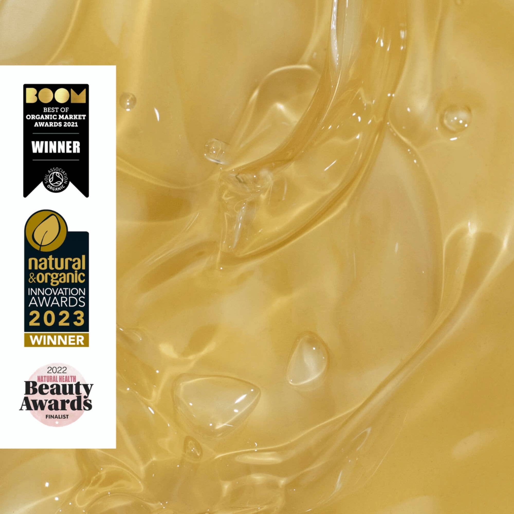 Gold liquid with beauty awards on a white background