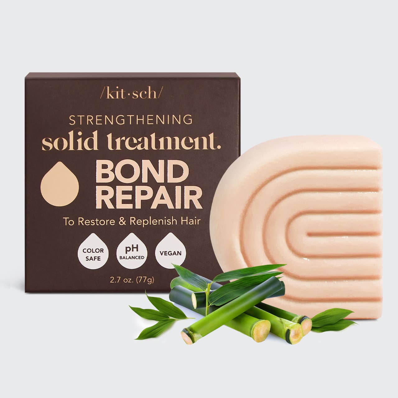 Kitsch Bond Repair solid treatment bar with packaging and bamboo leaves on a light gray background