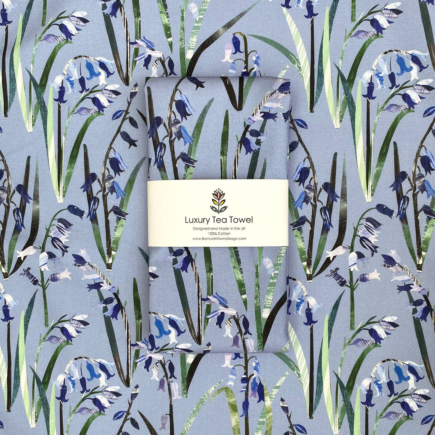 Tea towel with bluebell design and 'Luxury Tea Towel' label on a matching background