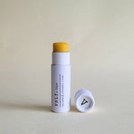 Vely Lip balm with white container  on a light beige background