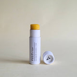 Vely Lip balm with white container  on a light beige background