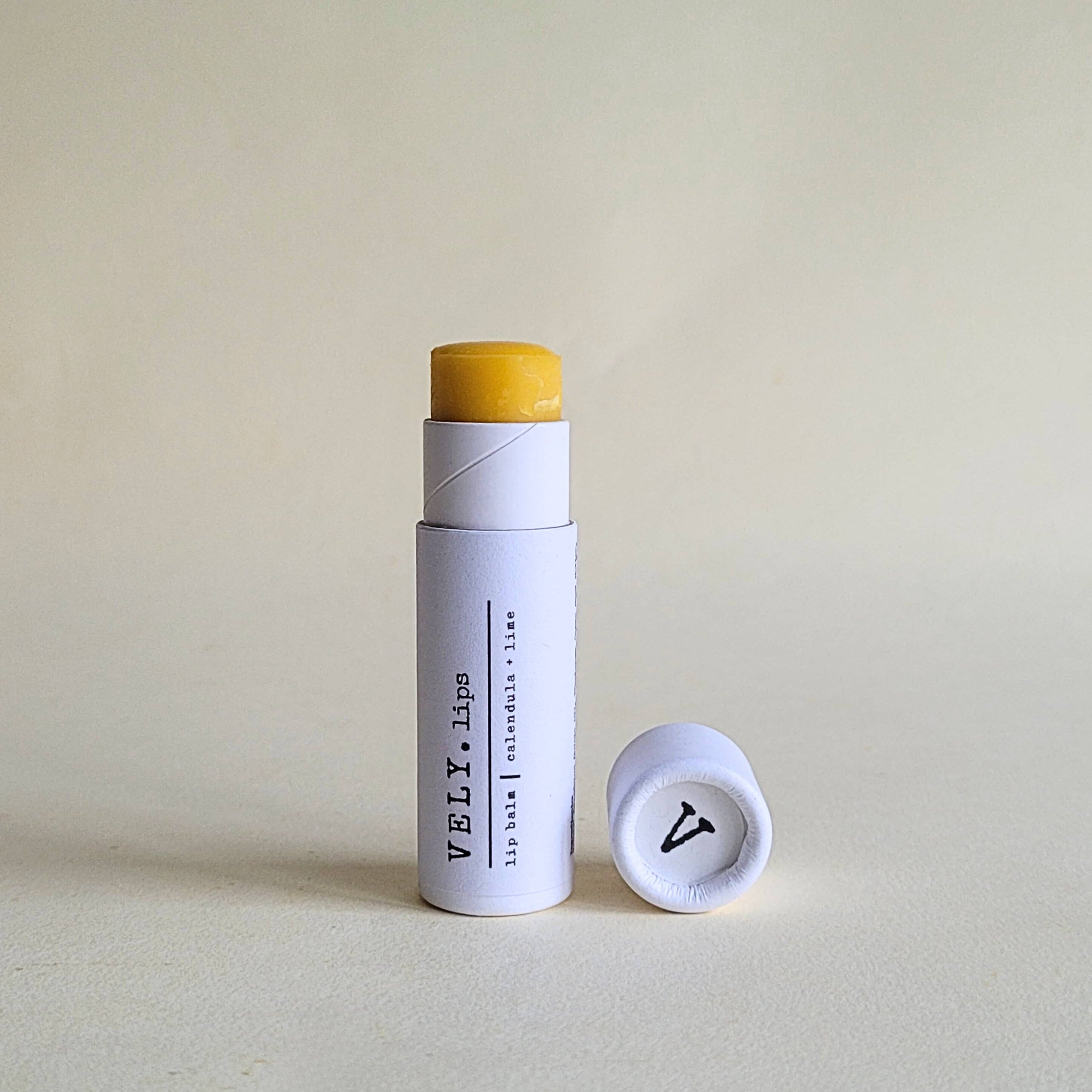 Vely Lip balm with white container  on a light beige background