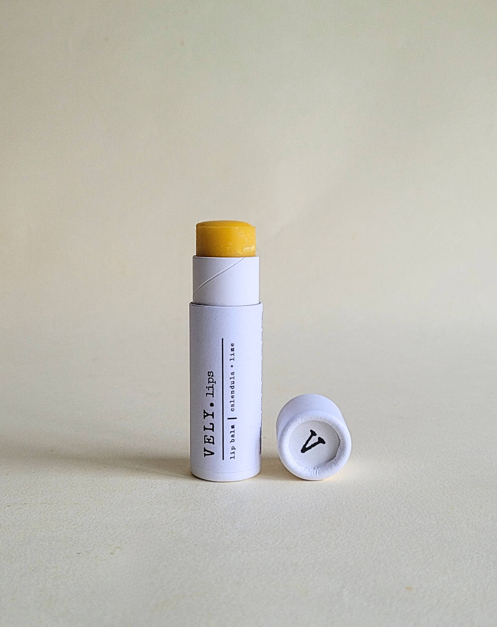 Vely Lip balm with white container  on a light beige background