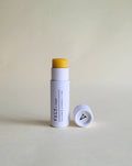 Vely Lip balm with white container  on a light beige background