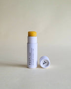 Vely Lip balm with white container  on a light beige background