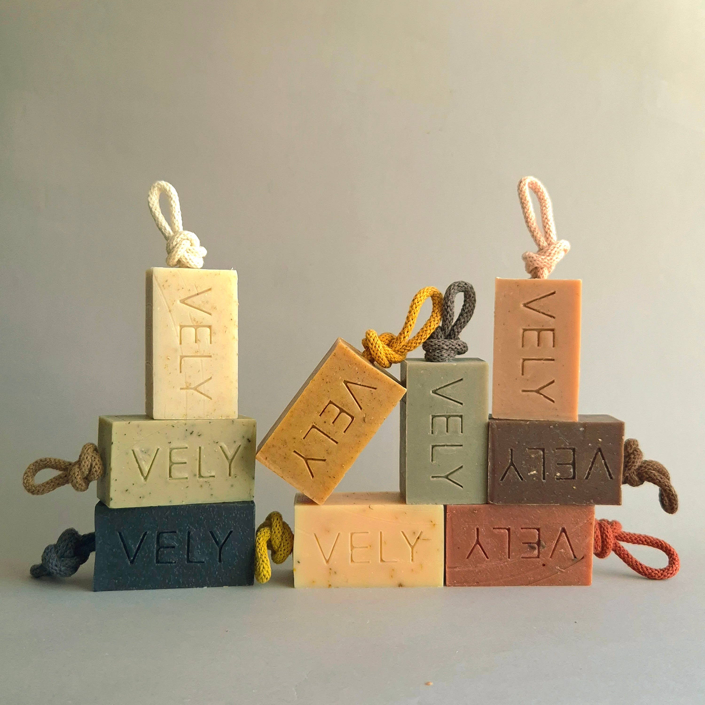 Set of VELY soap bars with rope handles on a neutral background