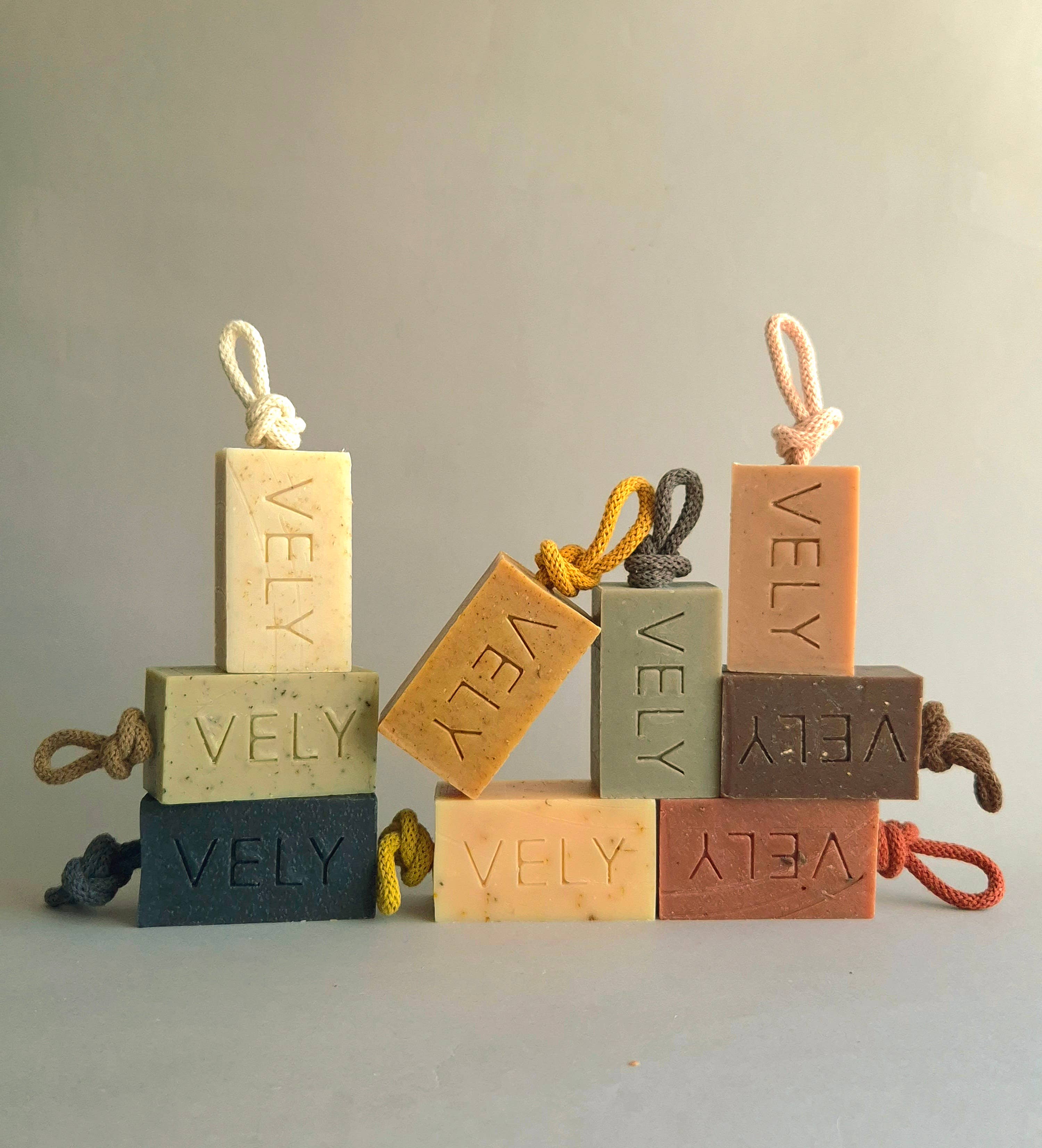 Set of VELY soap bars with rope handles on a neutral background
