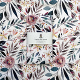 Set of pink floral patterned tea towels with a visible brand label on a matching floral background.