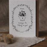 Greeting card with floral design and text on a wooden surface