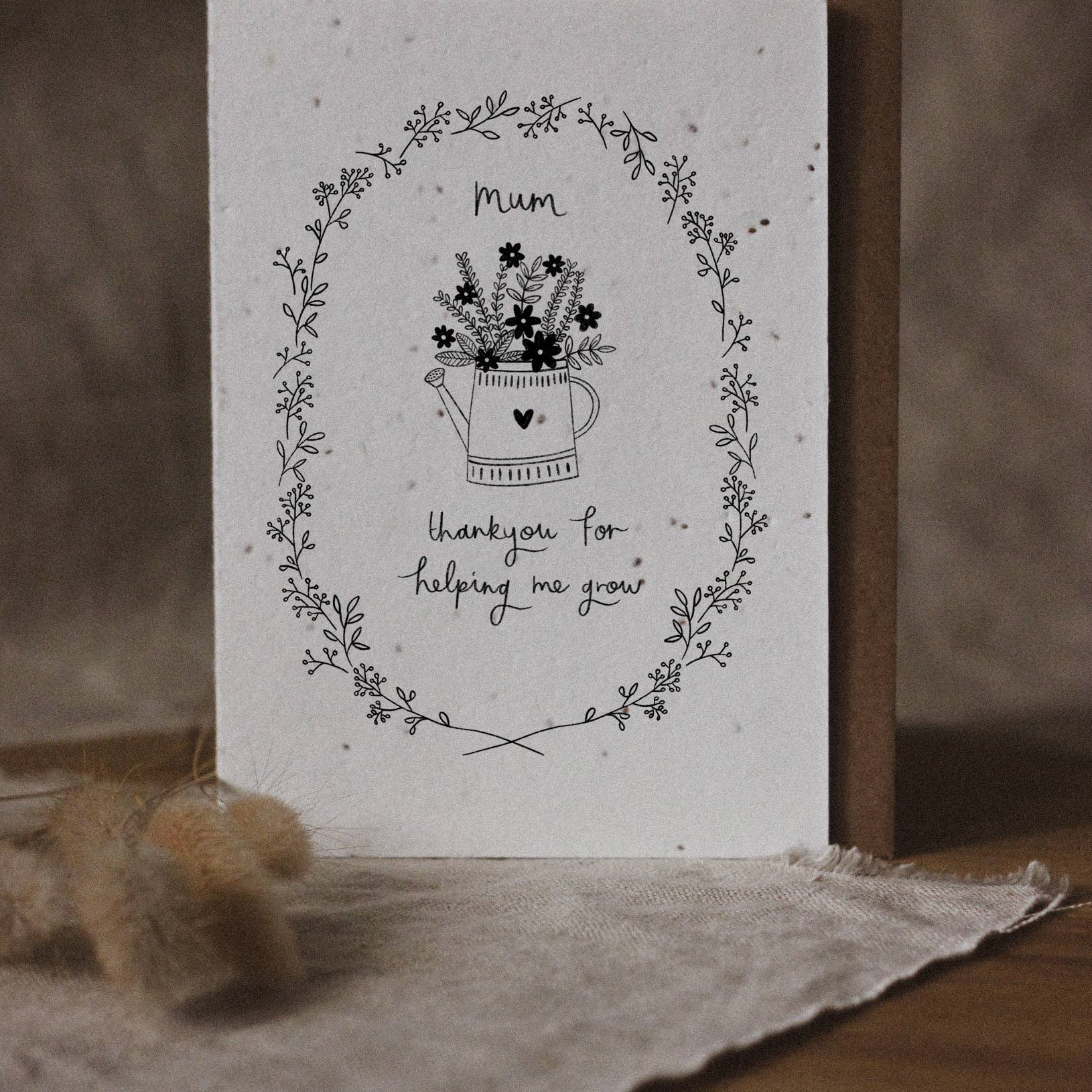 Greeting card with floral design and text on a wooden surface