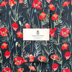 Tea towel with red poppy design and 'Luxury Tea Towel' label on a matching background
