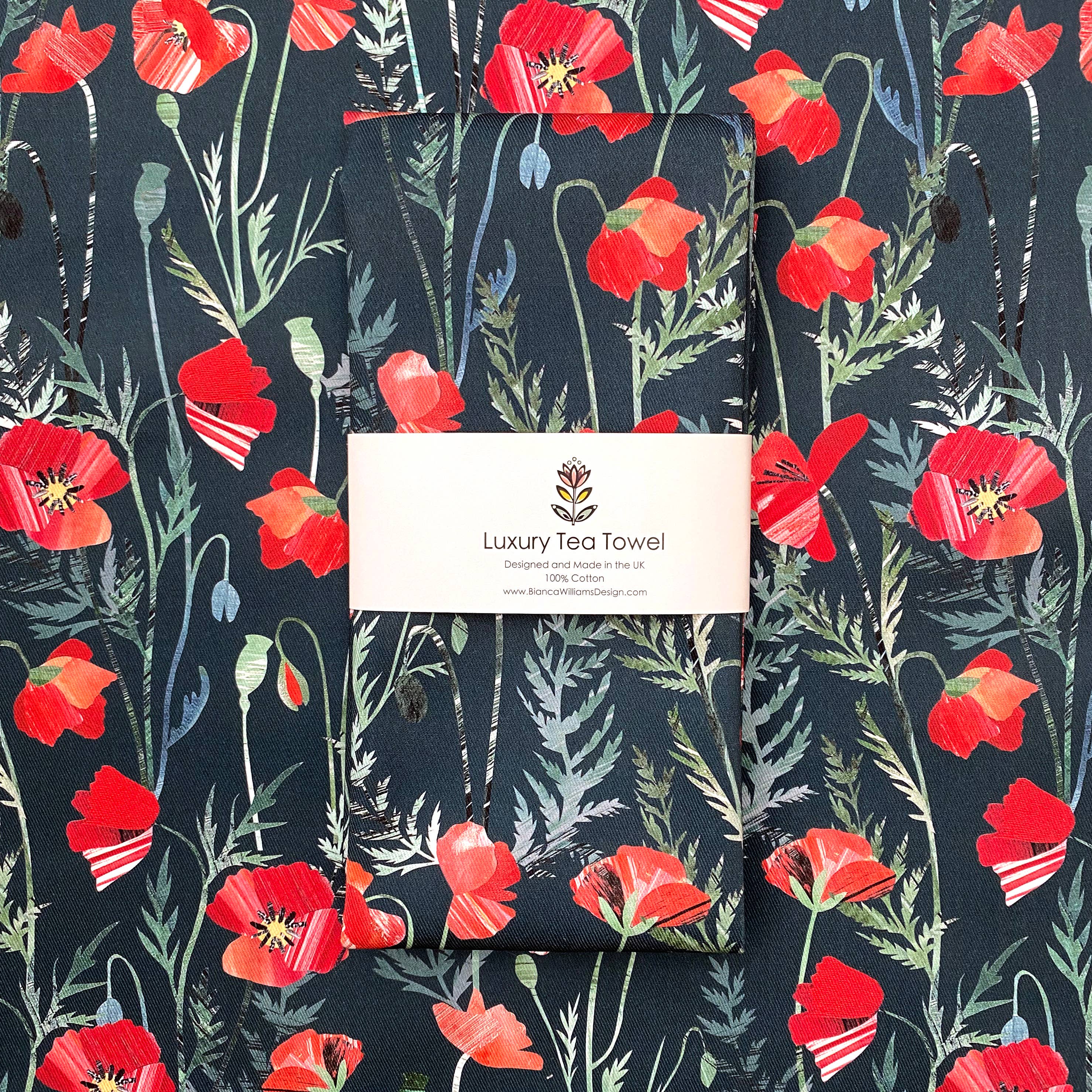 Tea towel with red poppy design and 'Luxury Tea Towel' label on a matching background