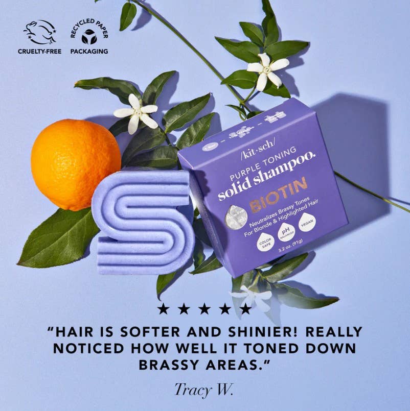 Purple shampoo bar with orange, leaves, and flowers on a blue background. 5* testimonial. Leaping Bunny cruelty-free logo.