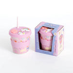 Pink tumbler with unicorn design and straw, displayed with its packaging on a white background.