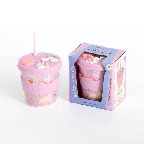 Pink tumbler with unicorn design and straw, displayed with its packaging on a white background.
