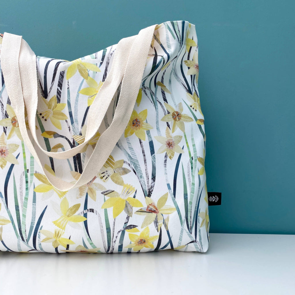 Bianca Williams Daffodil Floral tote bag with yellow flowers and green leaves on a white background