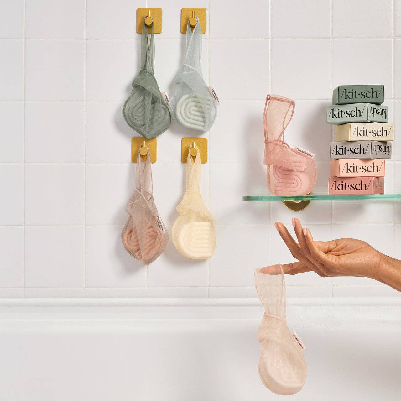 Selection of Kitsch solid shampoo bars and Kitsch solid conditioner bars in Kitsch saver bags, hanging on hooks with a shelf displaying Kitsch haircare product packaging.