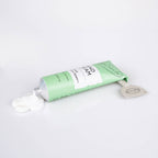 Green tube of UpCircle Hand Cream on a white background. White cream has been squeezed from the tube and a grey tube squeezer is at the top of the tube.