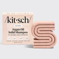 Kitsch argan oil solid shampoo bar and packaging on a light gray background